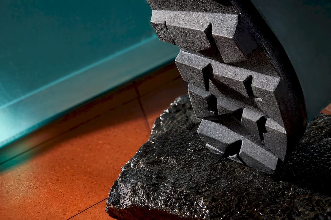 Close-up of lug sole tread on wet stone