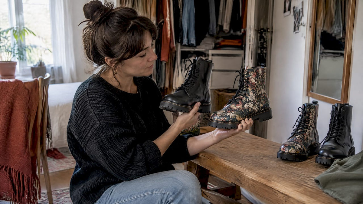 Shopper comparing two pairs of vegan combat boots